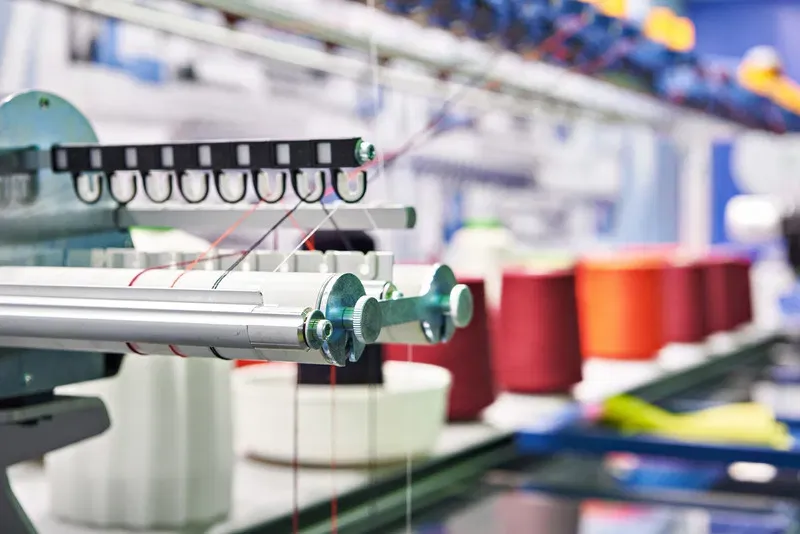 Detalle de maquinaria textil industrial y alimentación de hilos